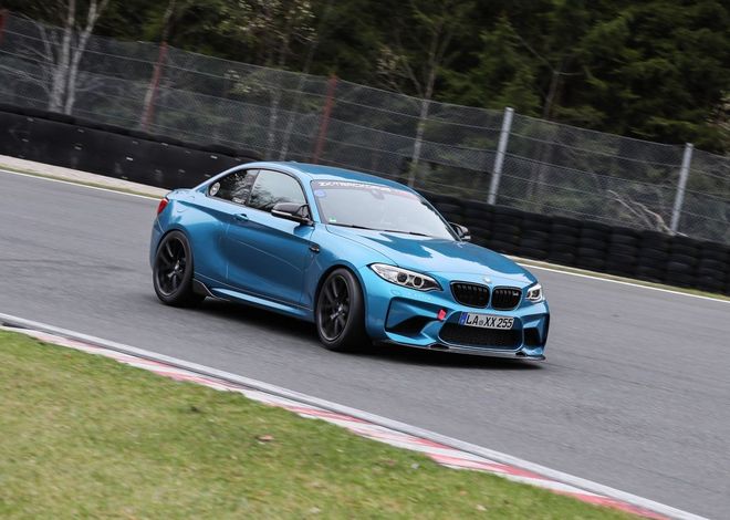 A blue sports coupé cornering on a race track